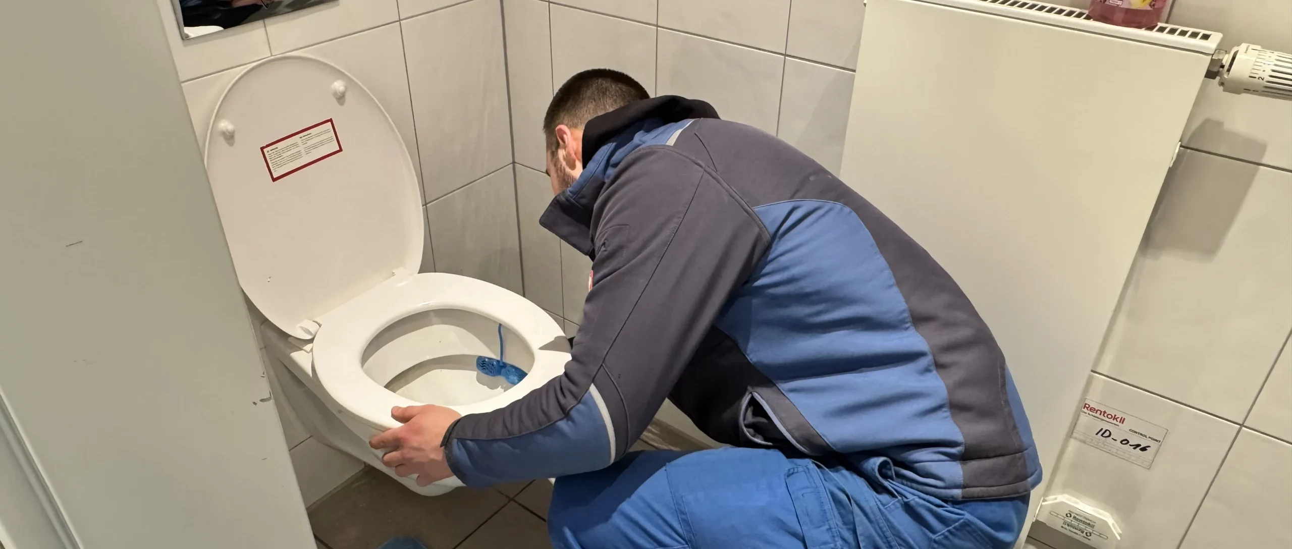 Technician fixing a toilet problem in the bathroom